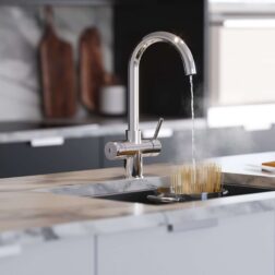 a chrome swan neck hot water tap dispensing water