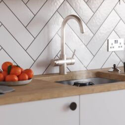 a brushed nickel swan neck hot water tap on a kitchen countertop