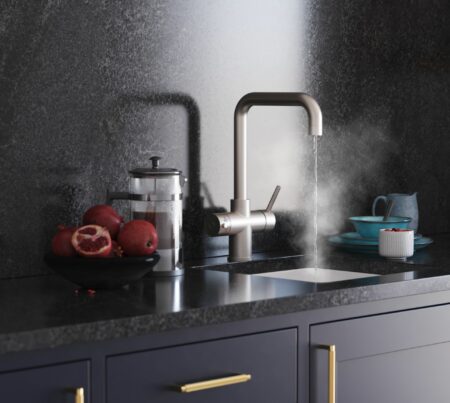 A black modern kitchen design with a stylish D-shape brushed nickel hot water tap dispensing streaming water over a white sink