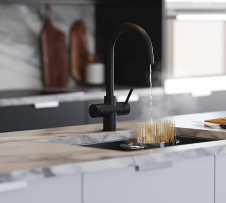 A swan neck water tap in matt black runs hot water over uncooked pasta in a pot
