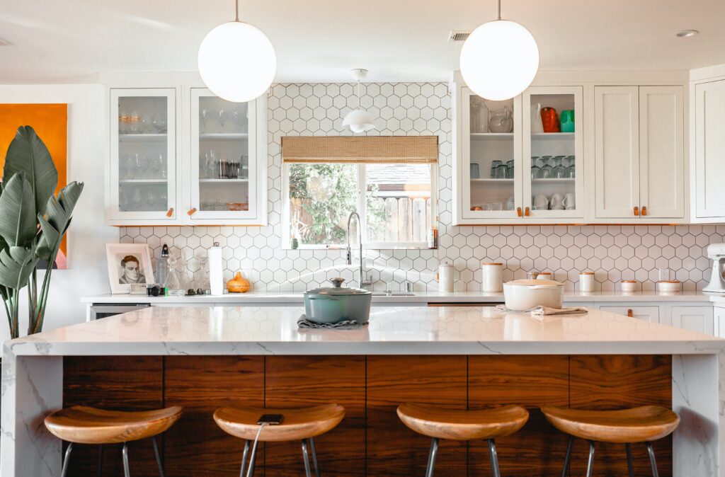 kitchen with a marble island, hexagonal white tiles and plants