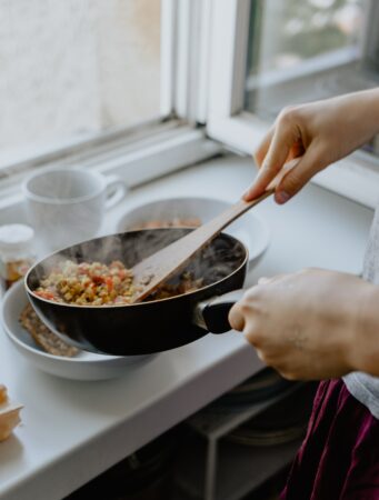 cooking vegetables using a black frying pan