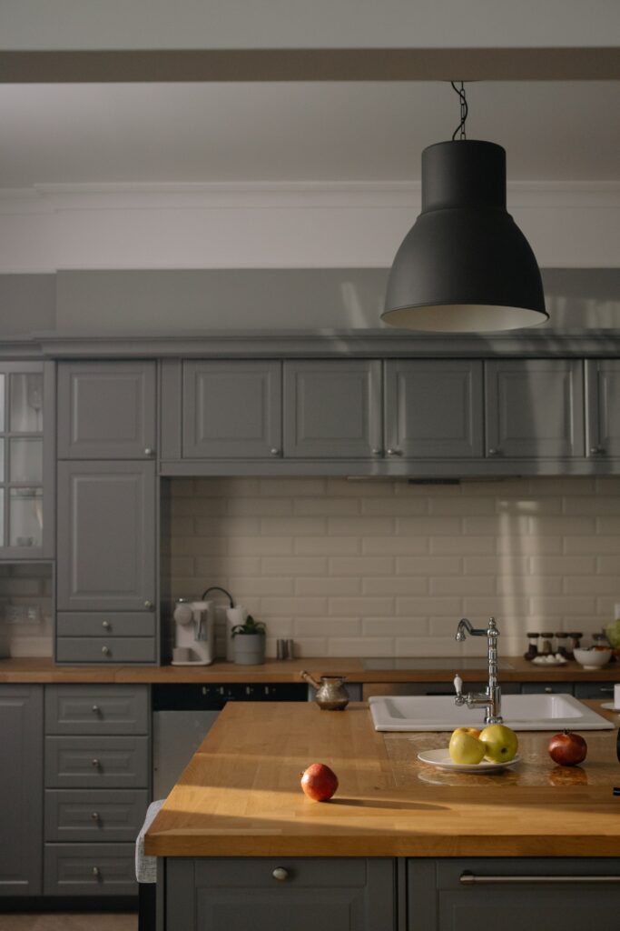 a wooden inspired kitchen with grey cabinets and a chrome water tap at the kitchen island