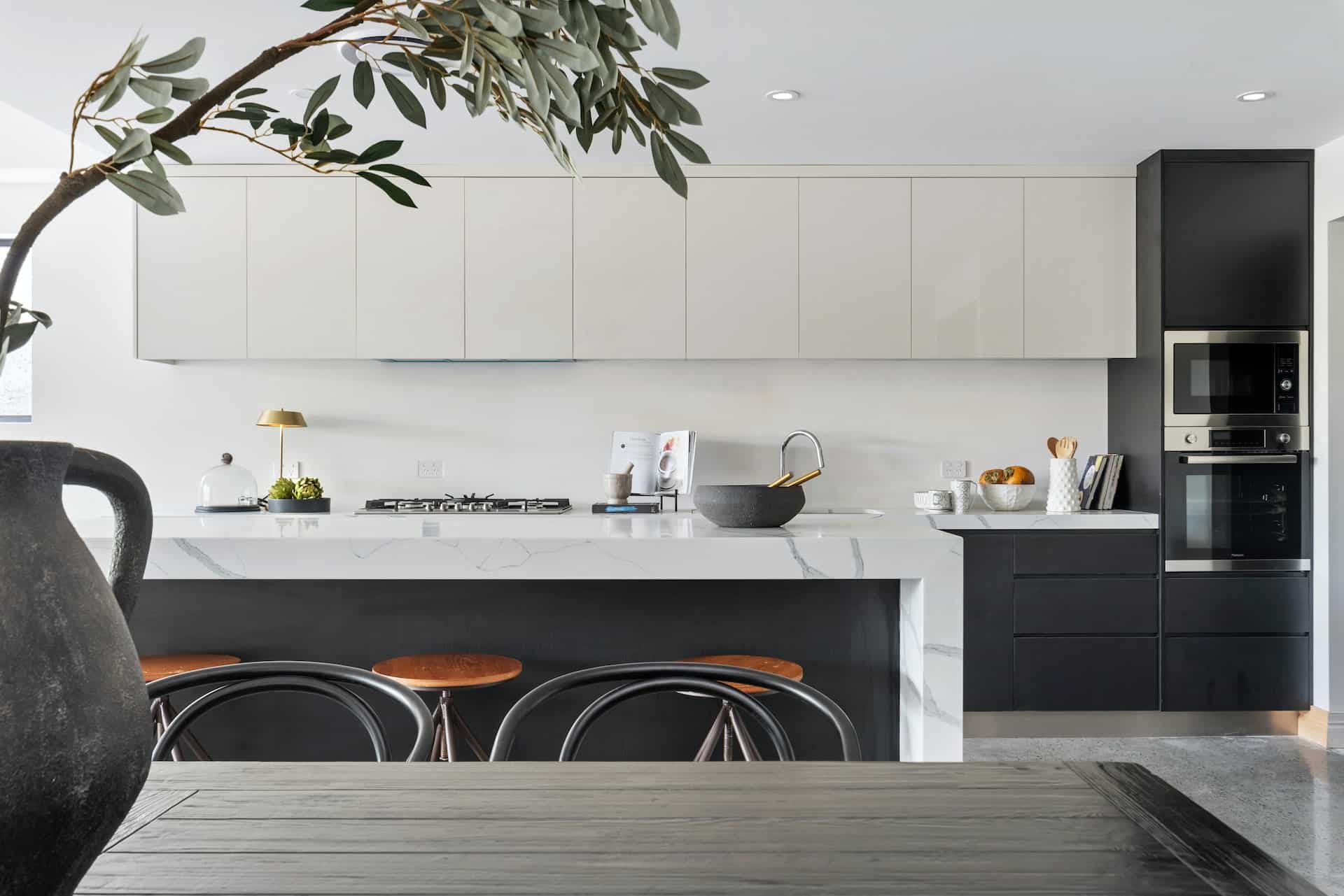 black kitchen cabinets and white worktops in modern, bright kitchen