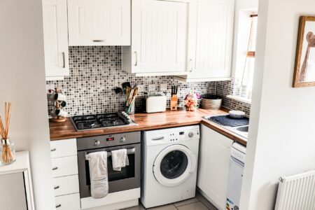 a small kitchen with white front load washing machine