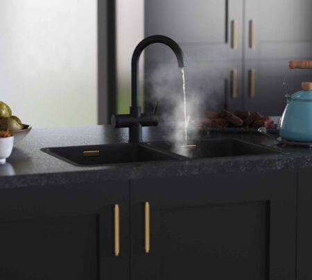 a matt black hot water tap beside a kettle