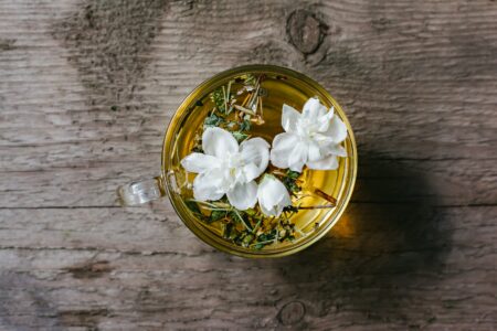 Cup of healthy floral tea placed on timber table