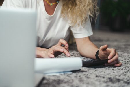 a woman uses a calculator to create a budget for kitchen remodel