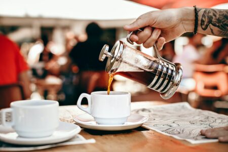 Person Pouring Coffee on White Ceramic Cup