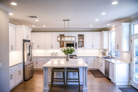 a kitchen interior with white wooden cupboards