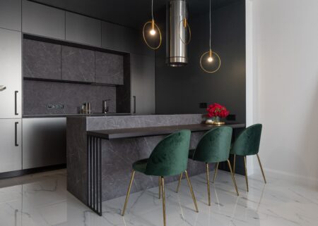 a grey kitchen with green chairs