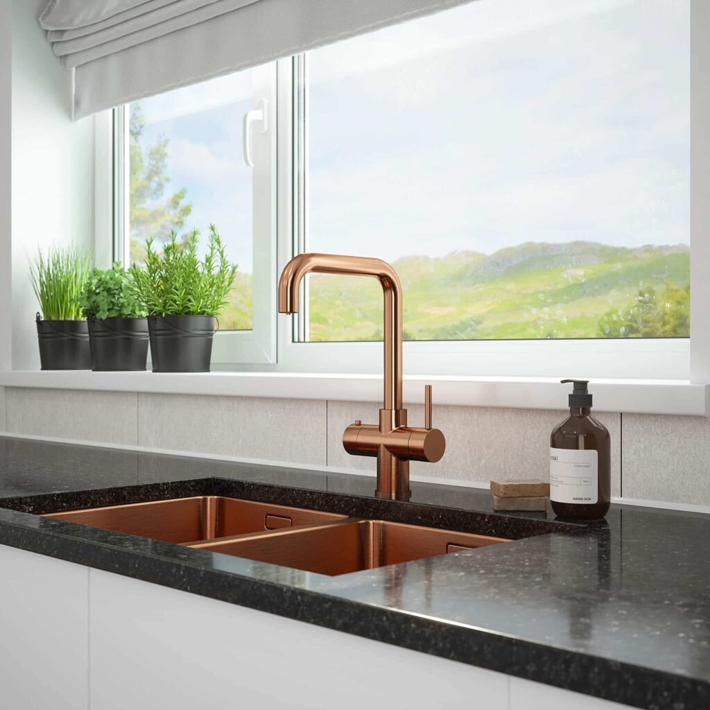 kitchen counter with square-shaped copper hot tap and sink in front of a wide window mountain view