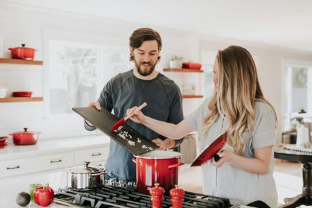 a man assisting a woman in cooking