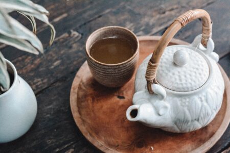 white and brown ceramic teapot on a wooden tray