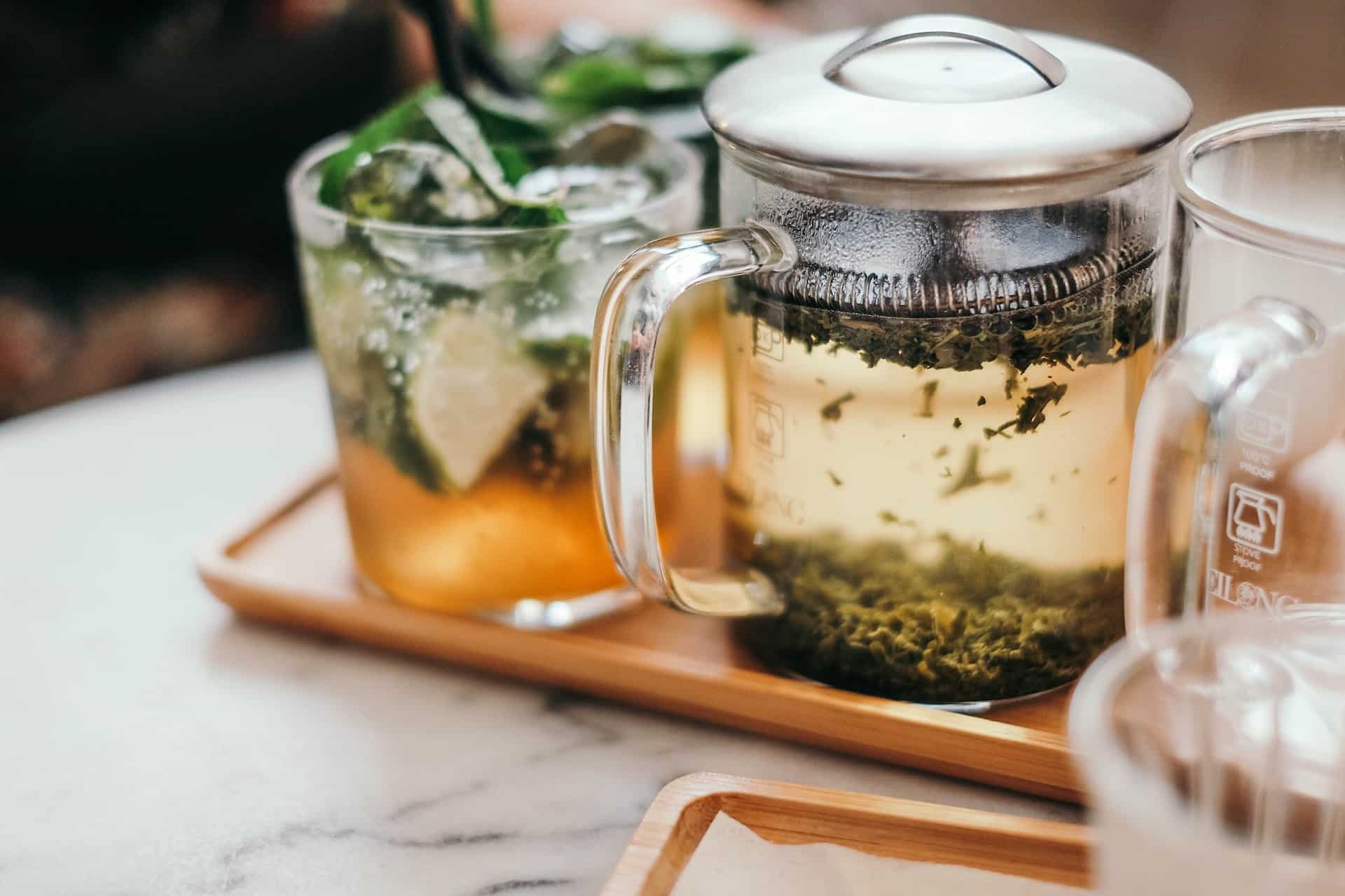 glass tea pot with loose leaf tea floating in water