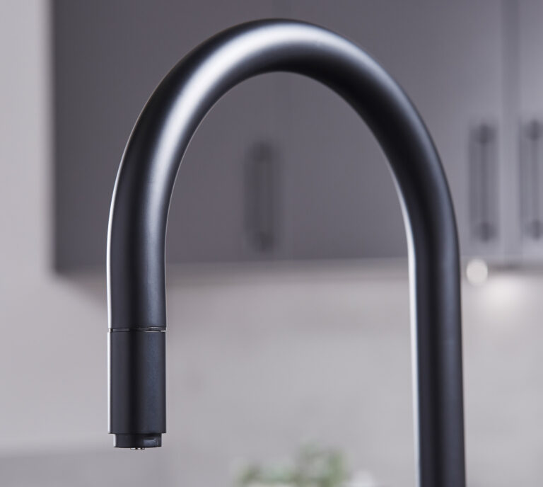 Close-up of a matte black hot water tap swan neck spout