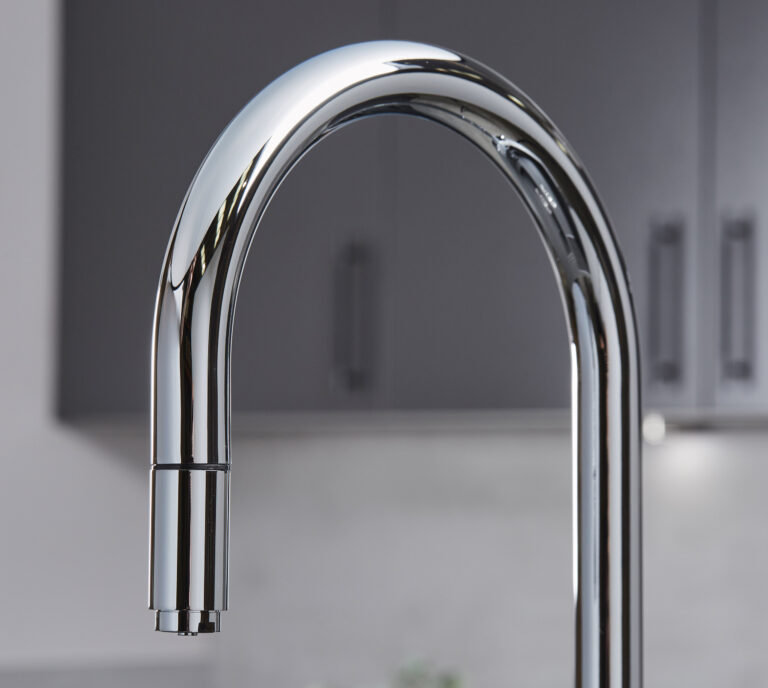 Close-up of a chrome hot water tap swan neck spout